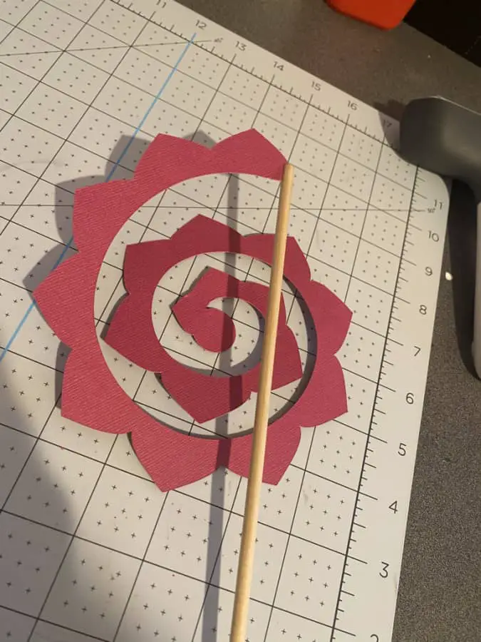 image of paper flower connect to end of dowel rod